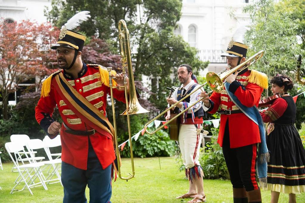 Die Besetzung eines Shakespeare-Stücks spielt Musikinstrumente in einem Londoner Garten