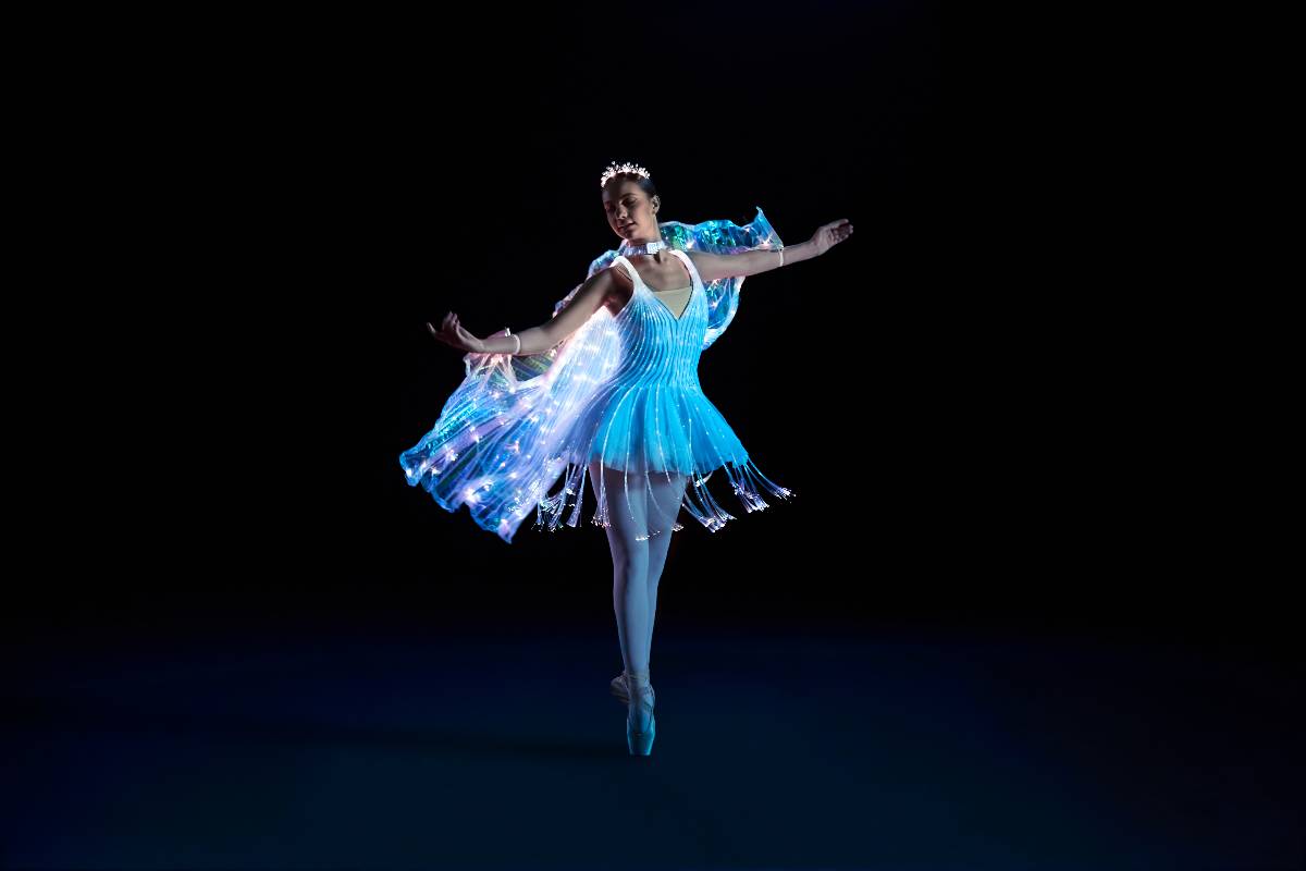 A ballerina dancing on stage wearing a costume with fibre-optic lights