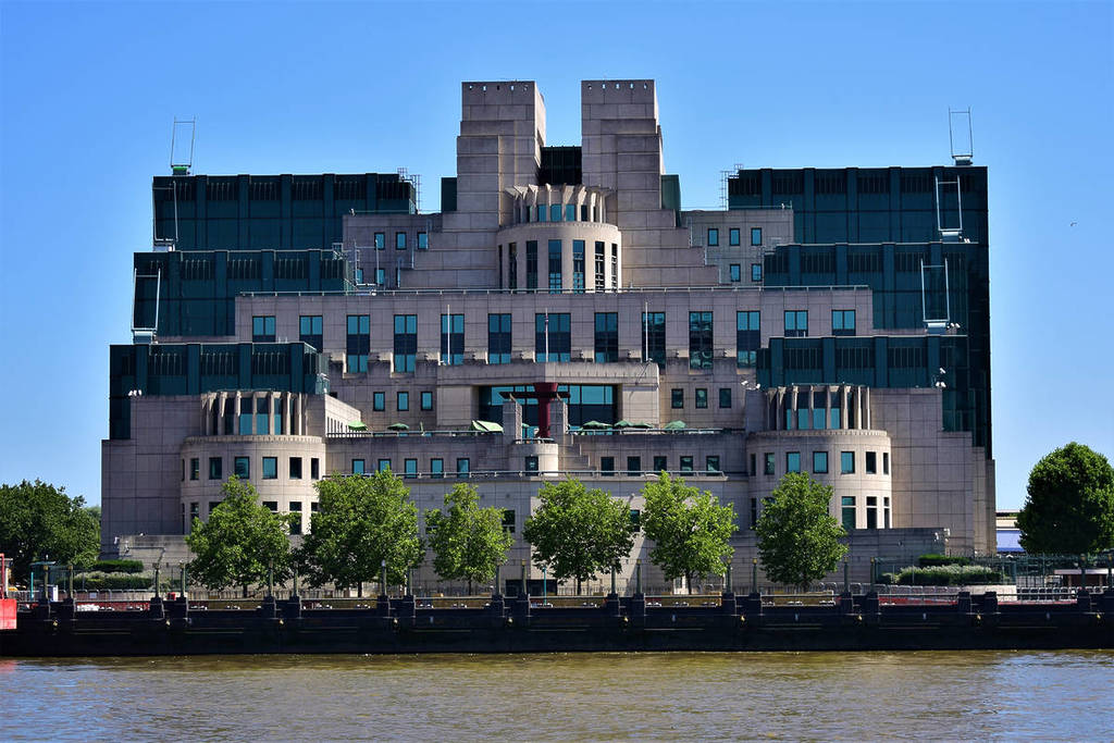 the exterior of the SIS building, with grand, fortress-like architecture, seen from the Thames