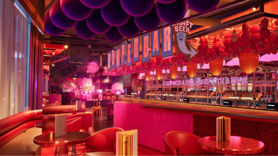 a pink-hued bar area with plush seating, tables, and neon signs