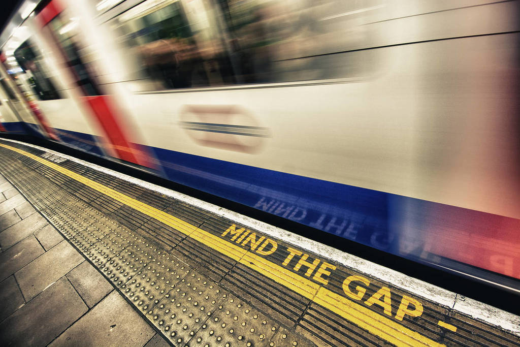 um comboio do metro de londres passa a correr por um aviso de 