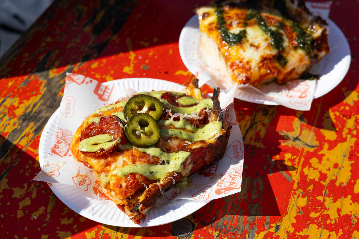 two thick slices of pizza - one is a a margherita topped with crispy basil, the other is a spicy pepperoni with a green sauce and jalapeno slices