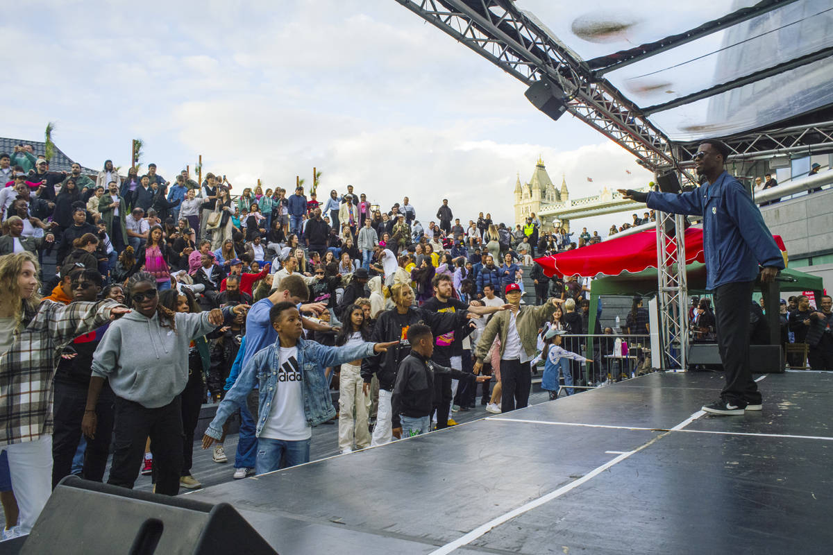 someone running a dance workshop on stage at the london bridge scoop as part of the summer by the river festival