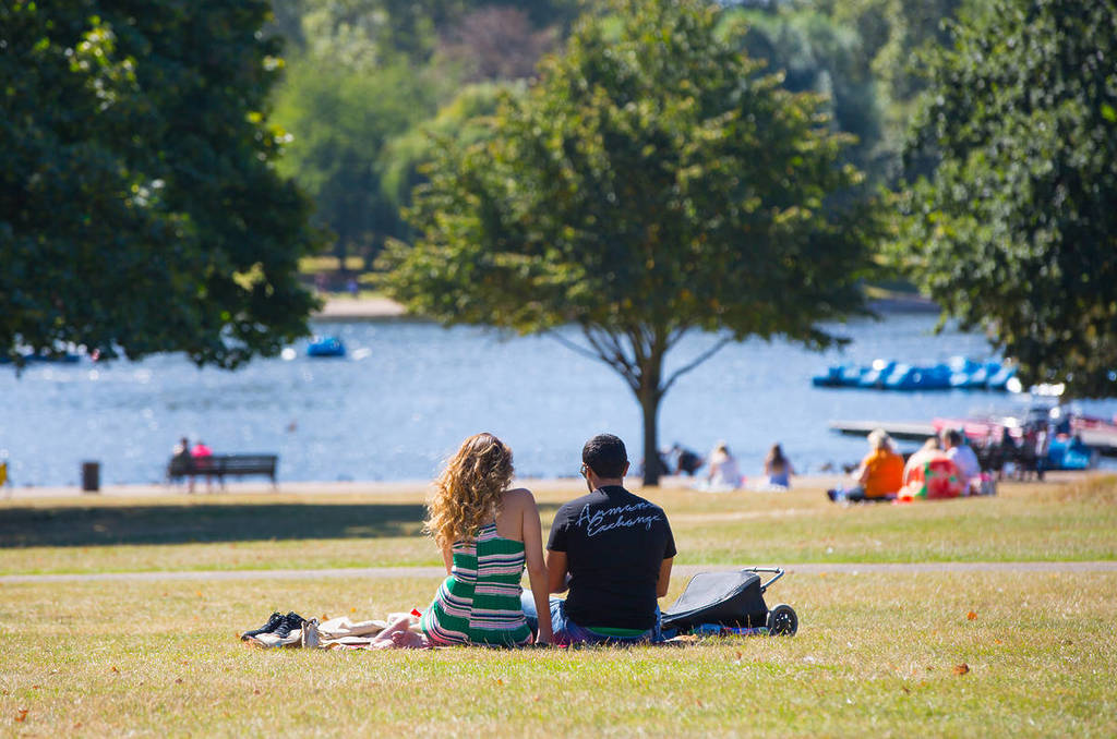 Pärchen beim Entspannen am See im Hyde Park, London
