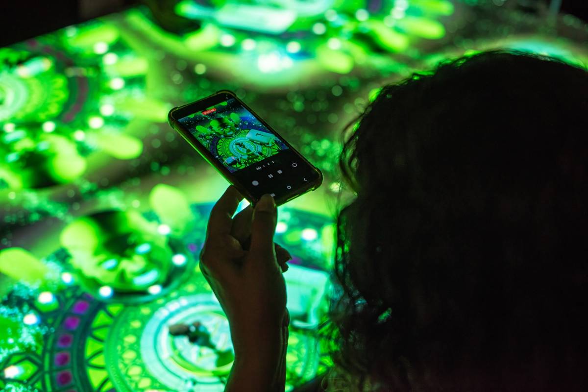 A woman taking a picture of her table at Sensory Feast
