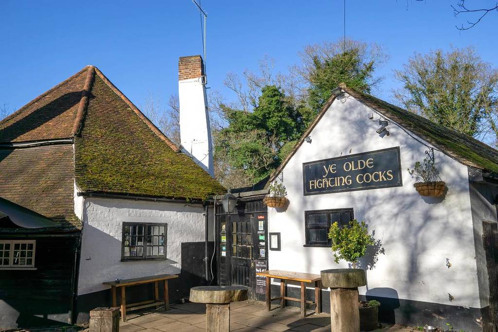The front of Ye Olde Fighting Cocks pub under a bright blue sky