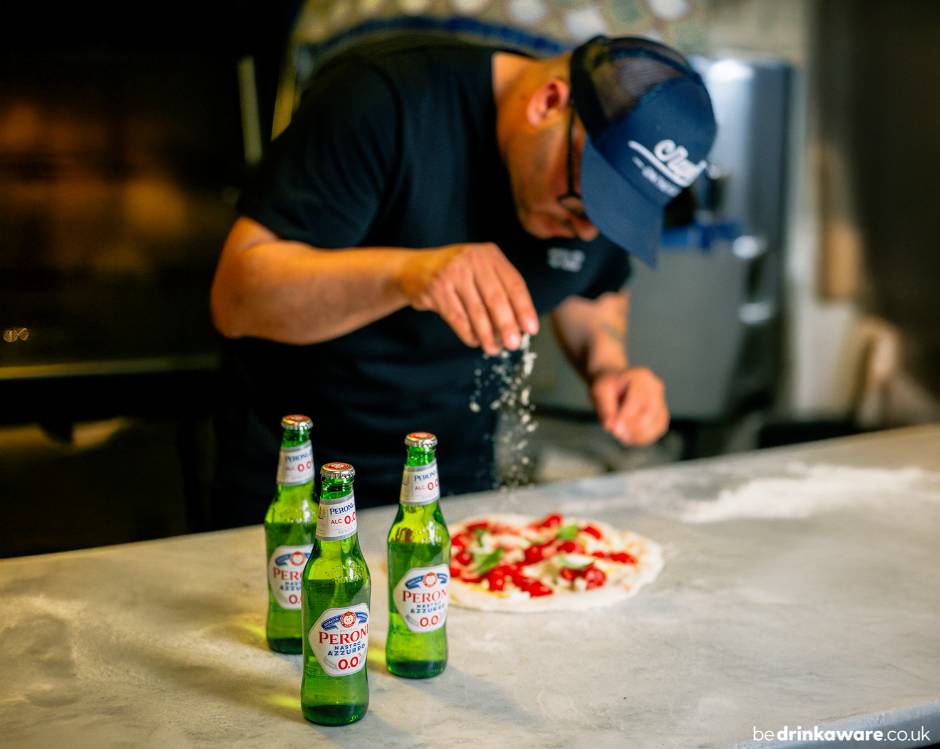 pizza chef Michele Pascarella making a pizza with 3 Peroni Nastro Azzurro 0.0% bottles on the countertop