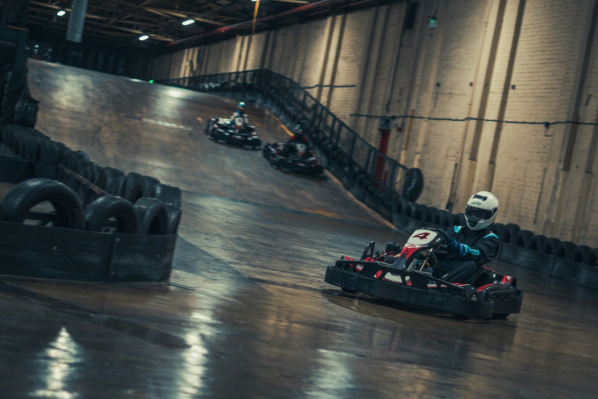 an indoor go karting track with three players racing