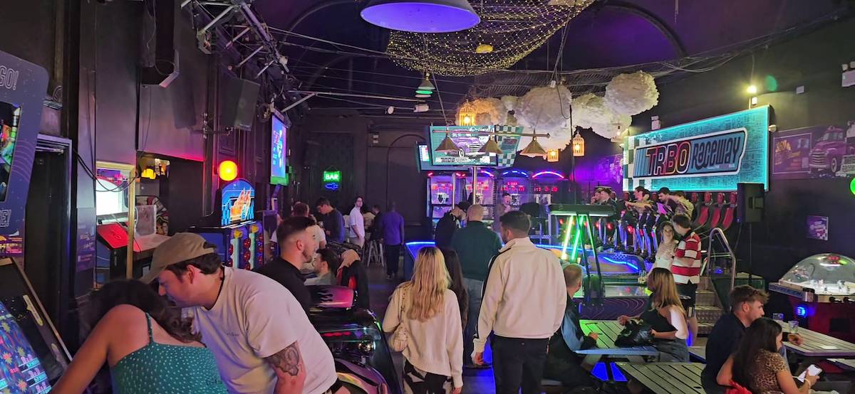 a neon-lit arcade where people play games