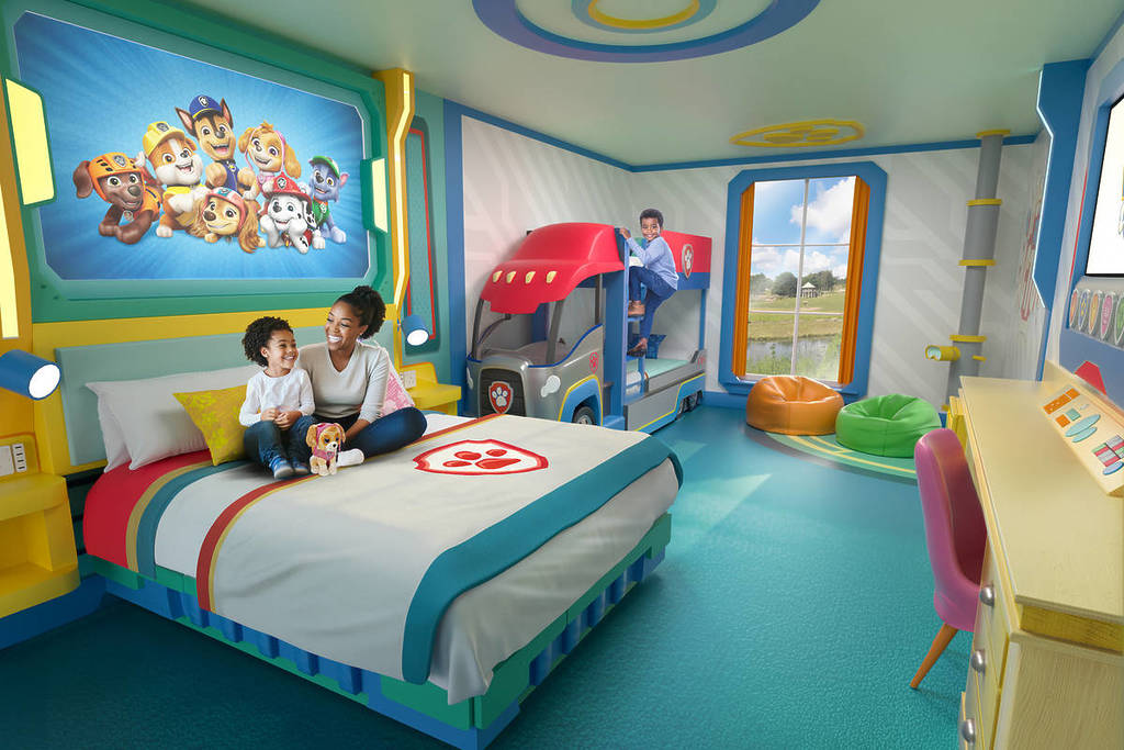 Ein CGI-Bild eines neuen Paw Patrol-Hotelzimmers in Chessington mit einem Doppelbett, einem Etagenbett, das dem Paw Patroller aus der Serie nachempfunden ist, und allgemeiner PAW-Patrol-Themenausstattung.