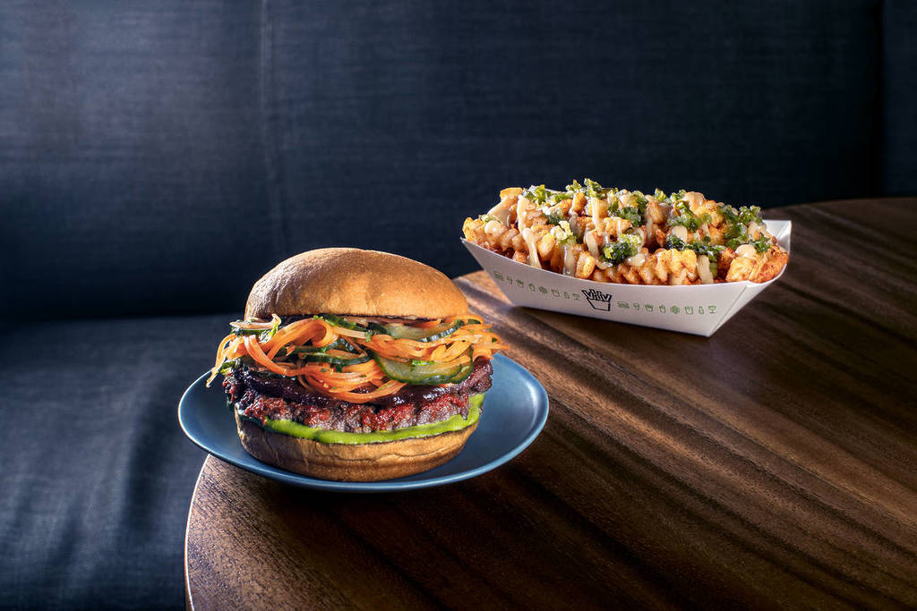 una versión especial con sabor tailandés de la hamburguesa y las patatas fritas de shake shack presentada en una mesa de madera