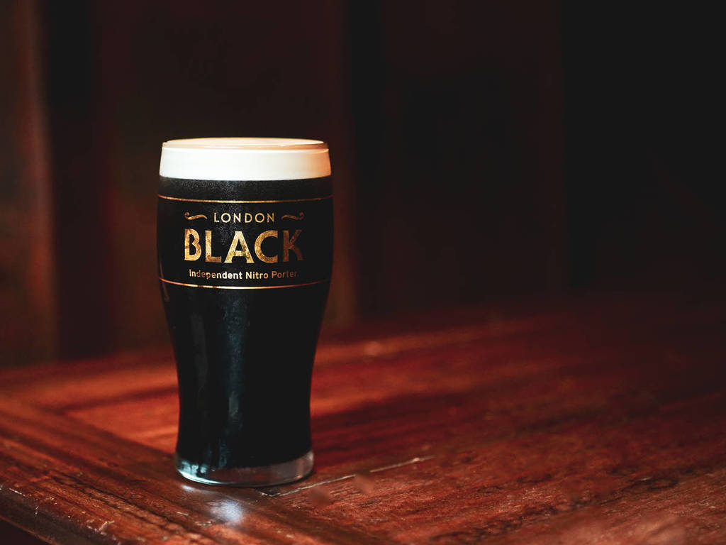 ein Pint eines dunklen Nitro Porter in einem Glas mit der Aufschrift 'London Black'