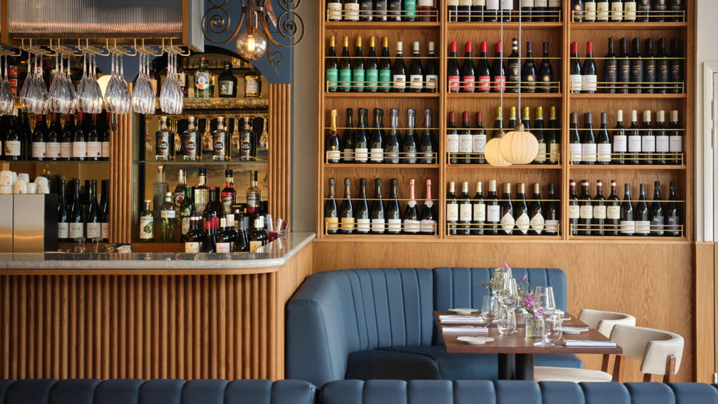 des étagères remplies de vin recouvrent les murs du restaurant le moins cher de londres, étoilé par le michelin