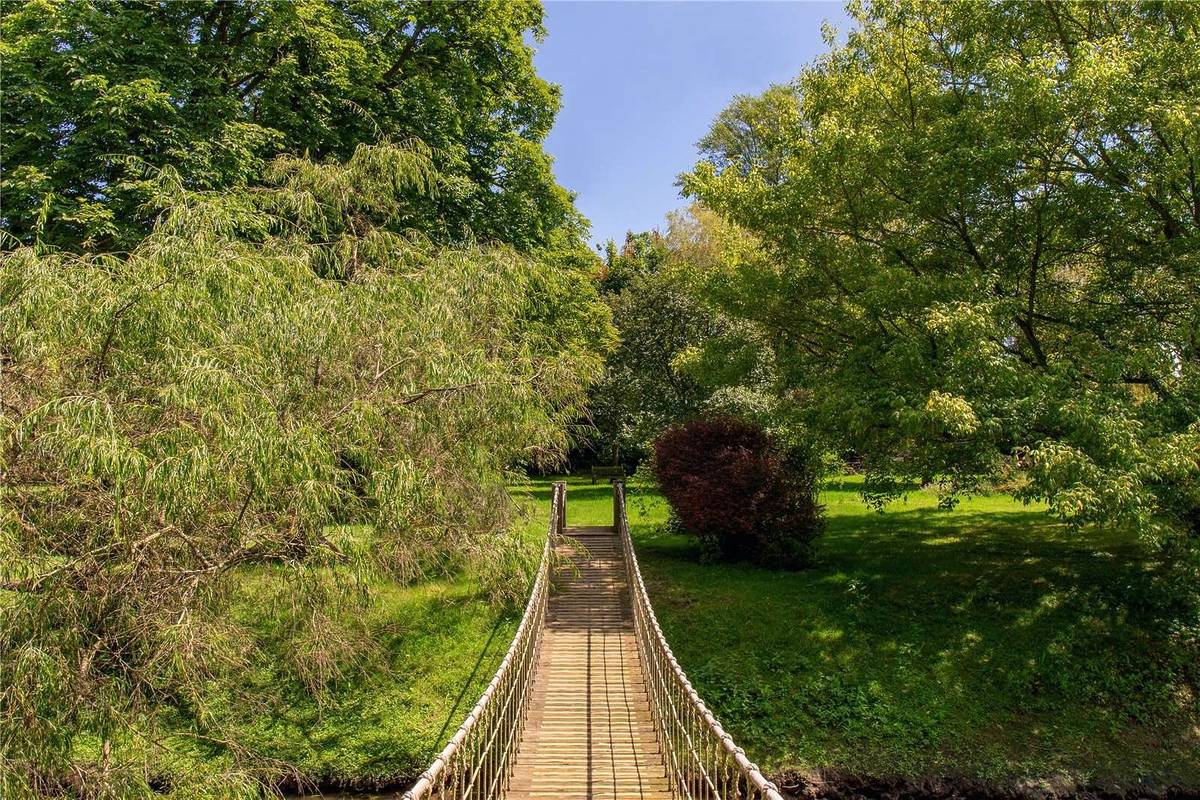 a ropeway bridge in a garden outside of tim burton's english country home