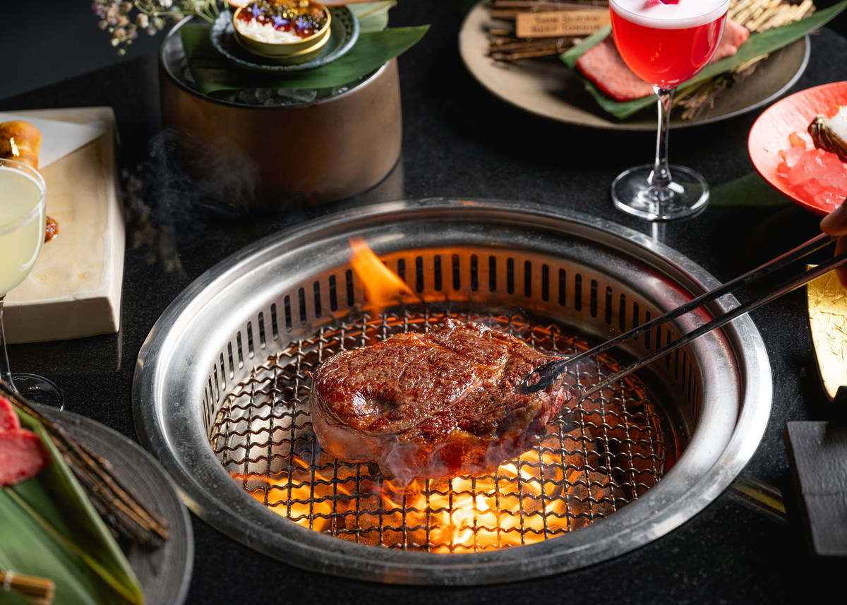 a steak cooking on a grill in a table