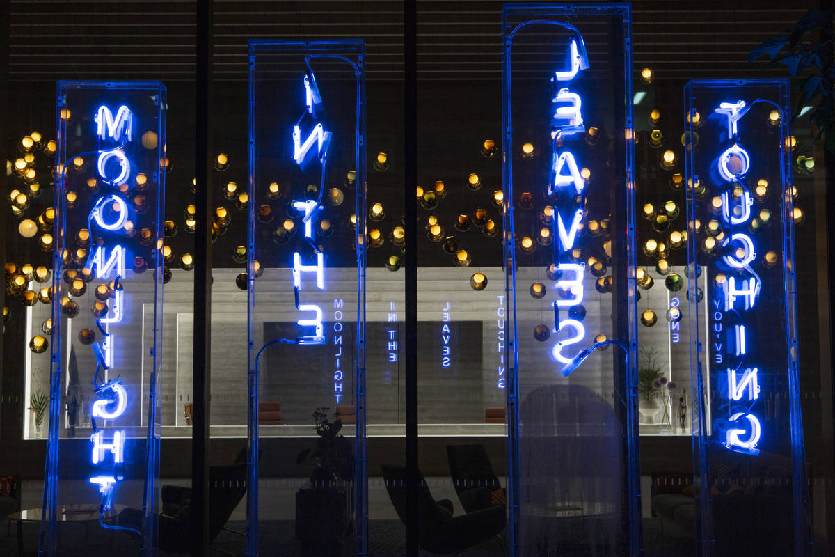 neon blue words floating in the air in a sculptural installation
