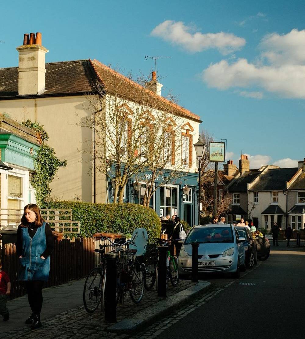 the exterior of the north star pub as seen from down the road, with the sun shining off the pub