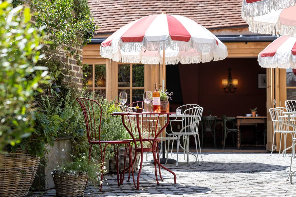 An outdoor table with sun parasol outside the Swan Inn pub