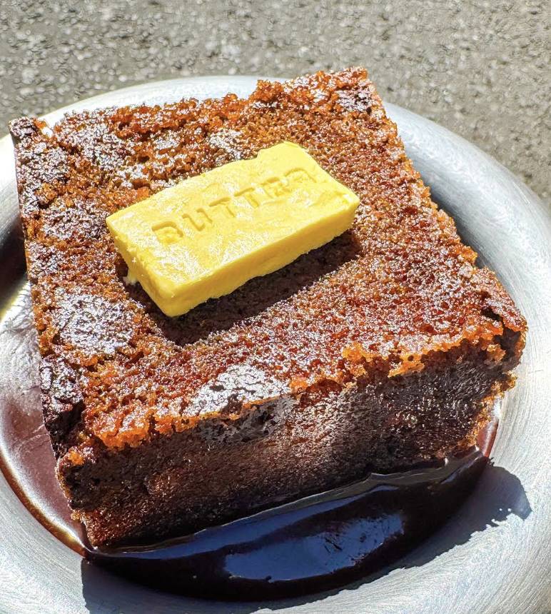 a piece of toasted banana bread topped with a butter pat shaped piece of ice cream