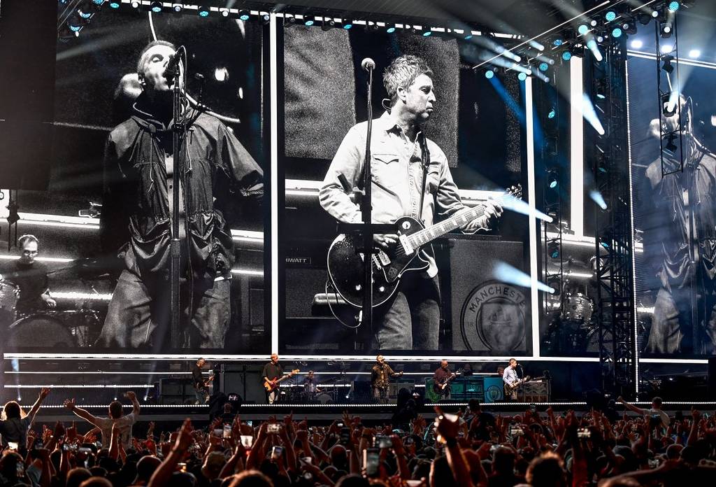 Noel Gallagher e Liam Gallagher sul grande schermo mentre gli Oasis suonano nel loro tour di ritorno