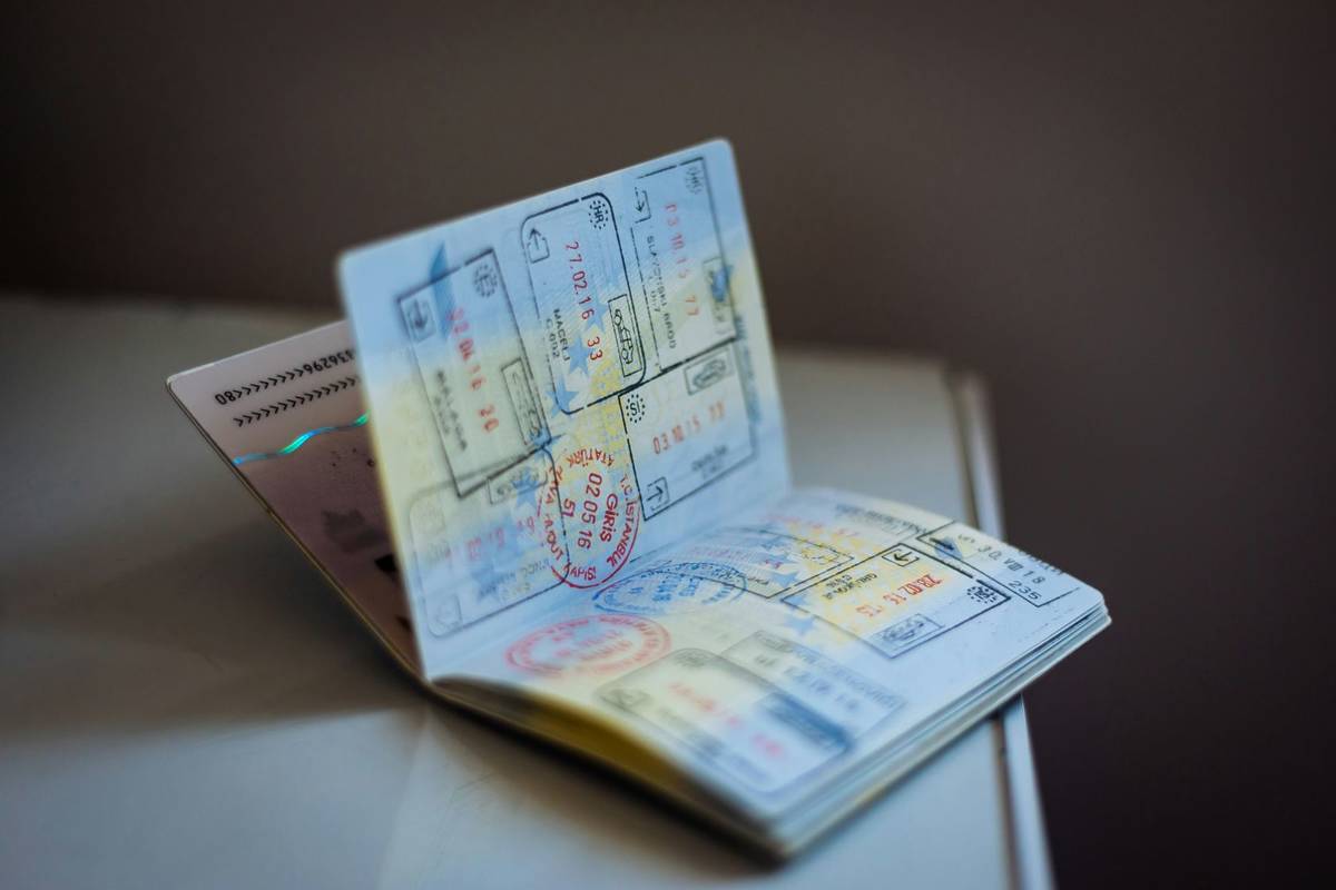 An open passport full of stamps