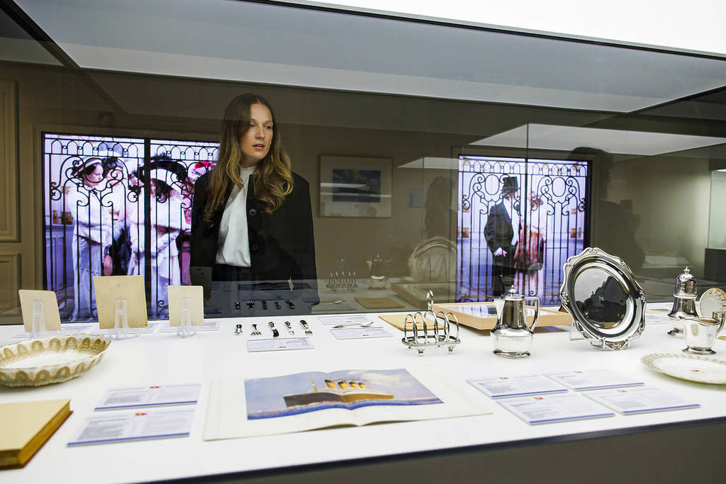 a woman looks at artefacts at the Legend of the Titanic exhibition
