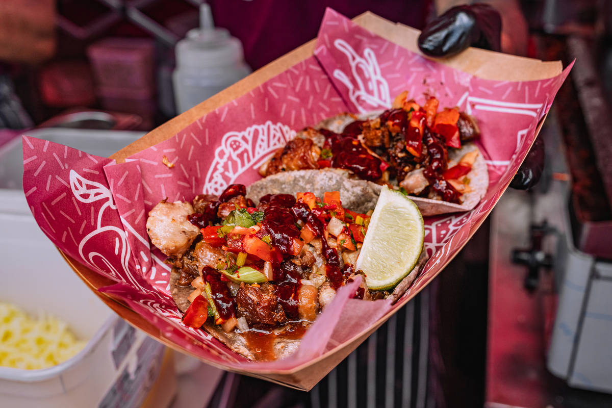 two hefty filled tacos in a tray with pink greaseproof paper underneath