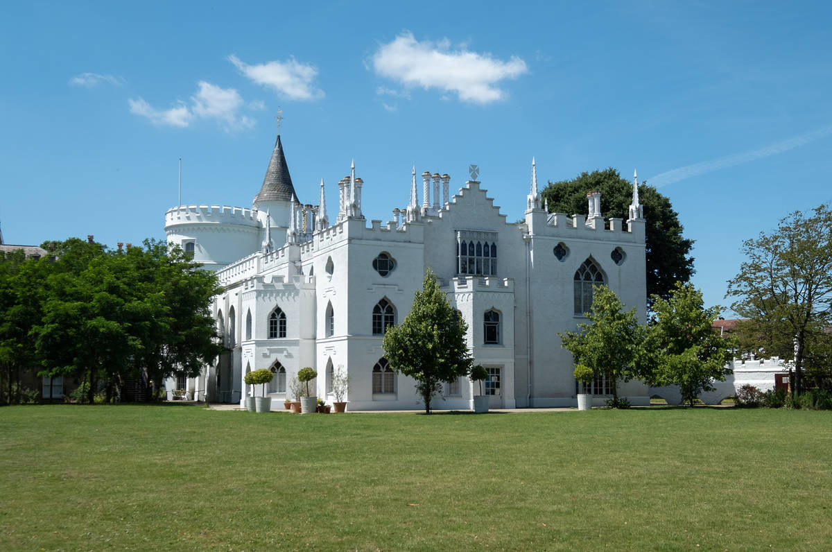 a white gothic castle with turrets in the middle of a green expanse in london