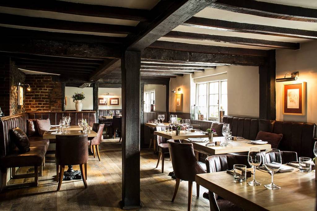 smart looking but still comfortable tables and chairs scattered around a rustic looking pub dining room