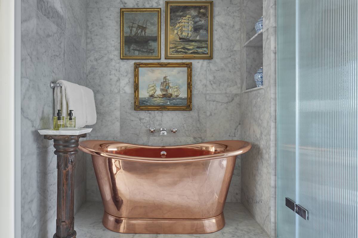 interiors of the bathroom of the edwardian cabin suite with a copper freestanding bathtub