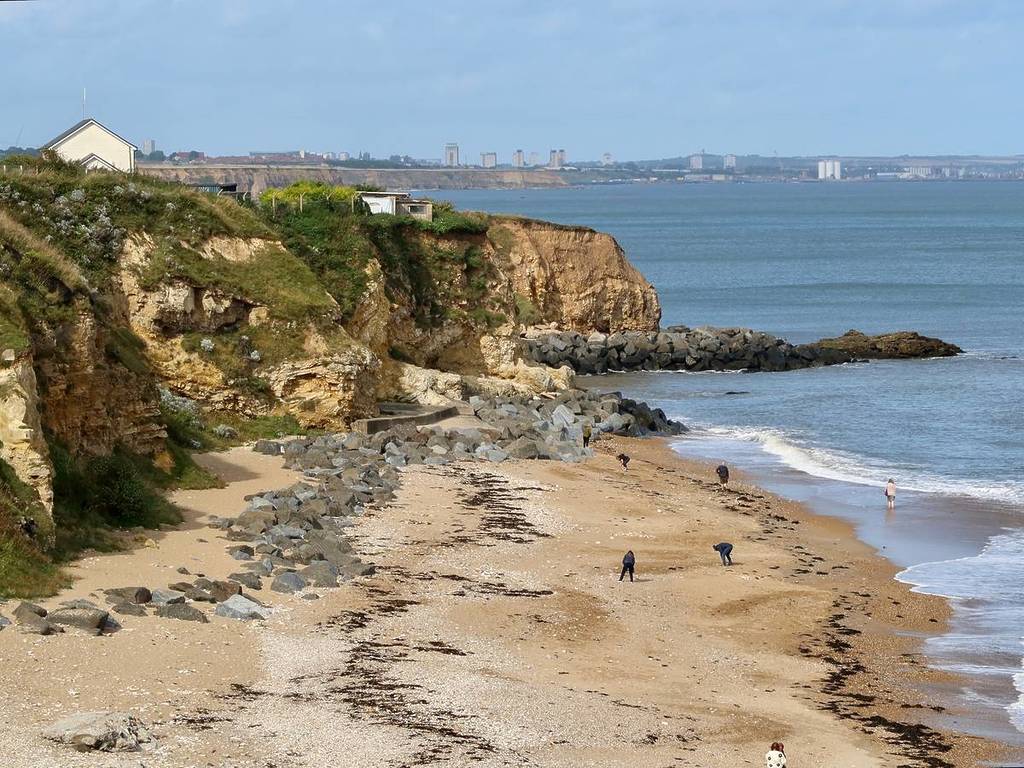 Seaham, County Durham, UK - 25 September 2023 : Blue sky, beach and cliffs. Sunderland visible in the distance.