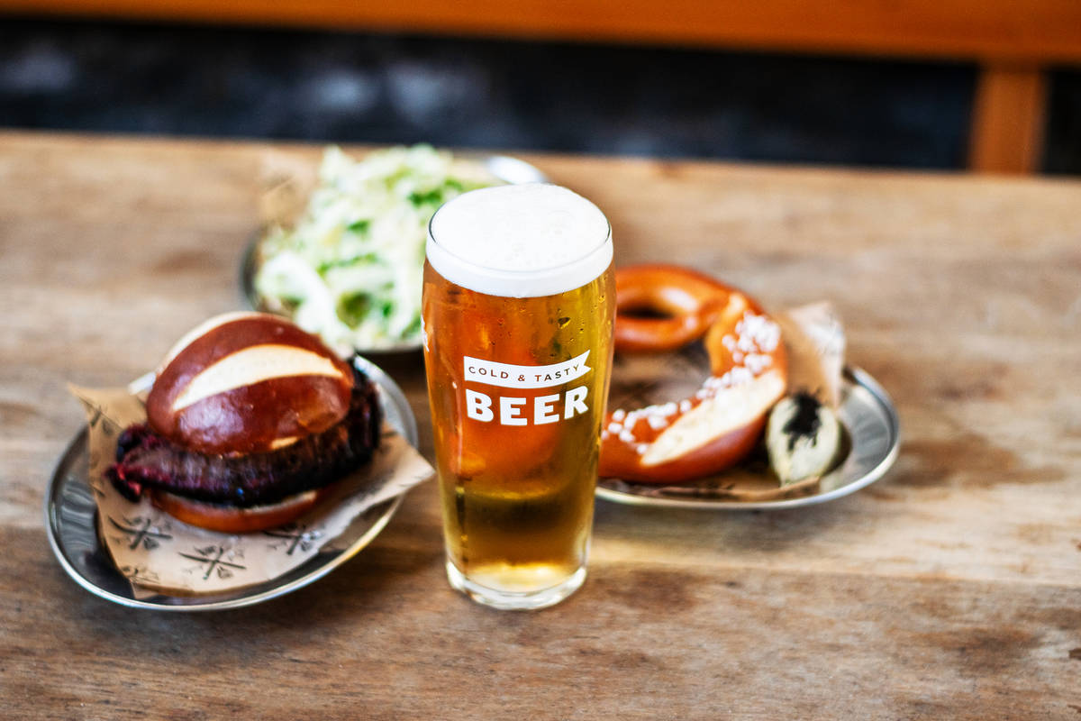 a pint of beer presented in front of oktoberfest inspired bbq food