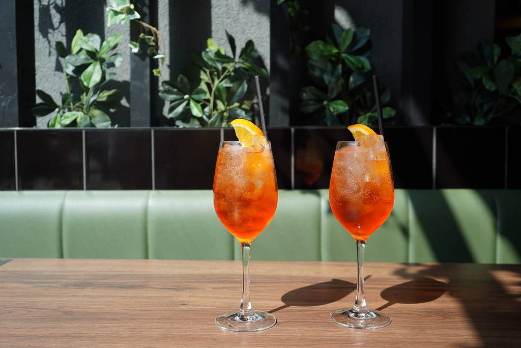 two aperol spritzes on a table in the sunshine