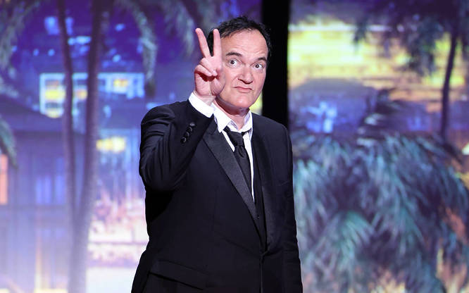 Quentin Tarantino doing the peace sign at the Cannes Film Festival in 2023