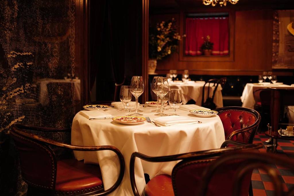 het sfeervolle en chique interieur in zwart en rood van het legendarische restaurant Carbone in New York met witte linnen tafels