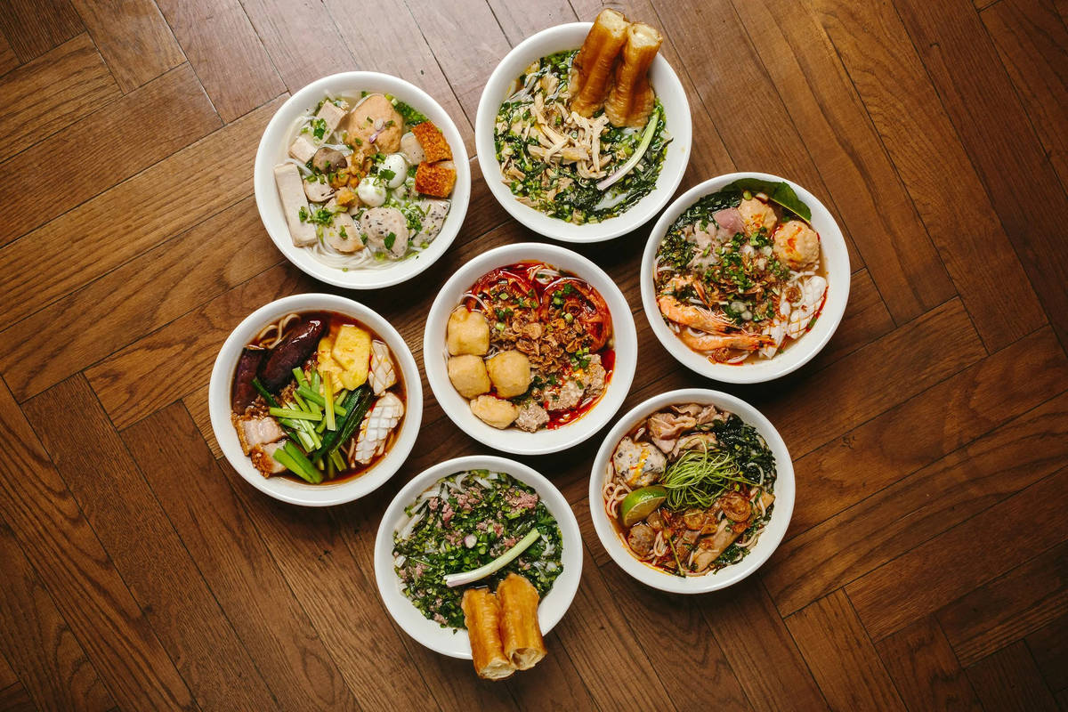 an array of borthy and soupu vietnamese dishes presented on a wooden table