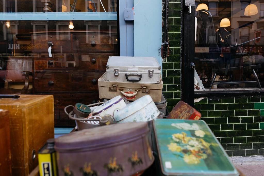 Stack of vintage suitcases and various vintage items in Chatsworth Road Market. T
