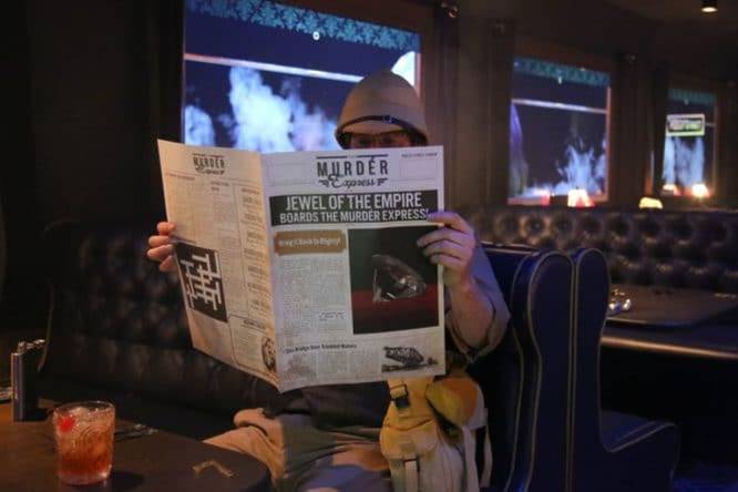 Person reading the newspaper on the Murder Express Experience in London