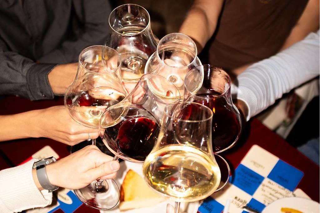 People clink glasses at The First Round.