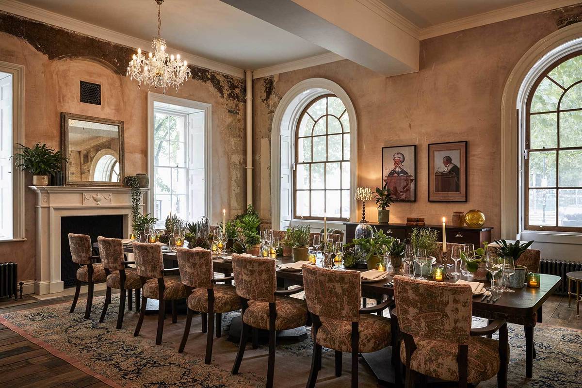 A long table decorated lavishly sits in front of two big, bright windows