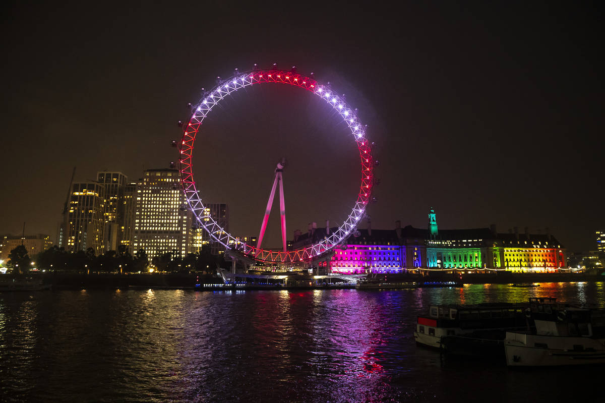 the london eye lit up red and white at night