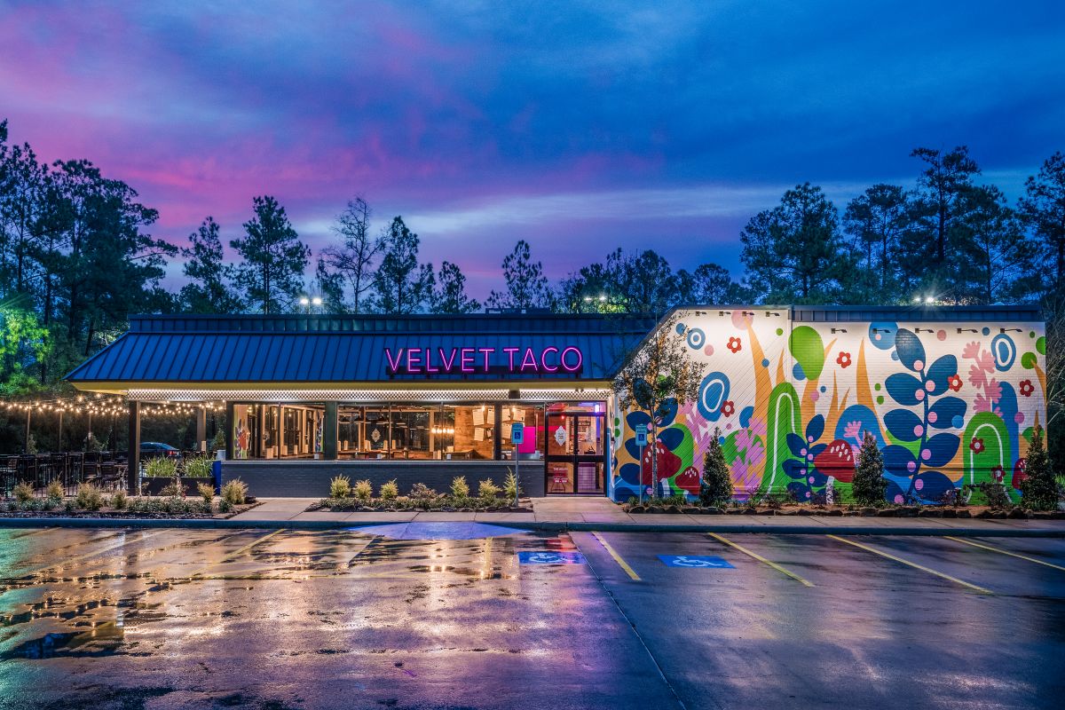 The exterior of a Velvet Taco store in the US at dusk