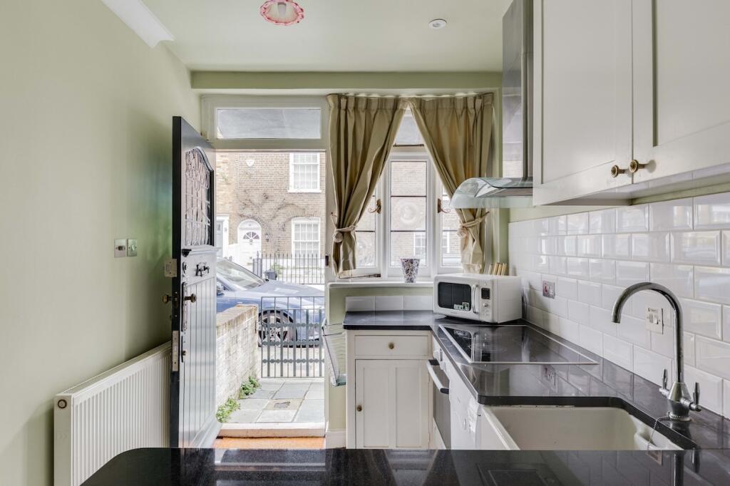 a view out the front door from the kitchen of the second narrowest house in london
