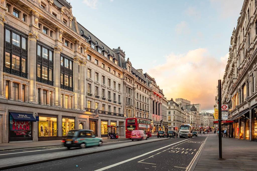 Une matinée tranquille dans une rue du centre de Londres avec un bus rouge à impériale et quelques voitures