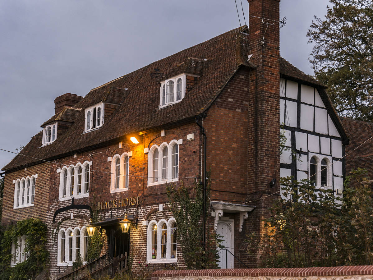 the red brick exterior of the black horse inn in pluckley