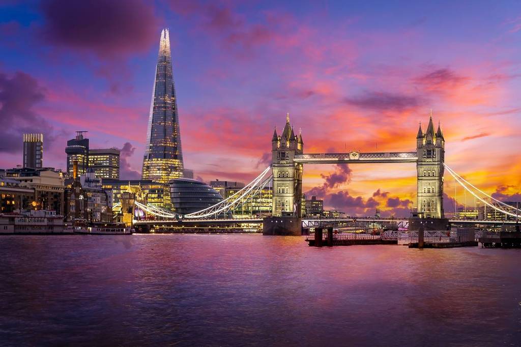 L'horizon londonien avec le Shard, le Tower Bridge et la Tamise au crépuscule sous un ciel rose et violet