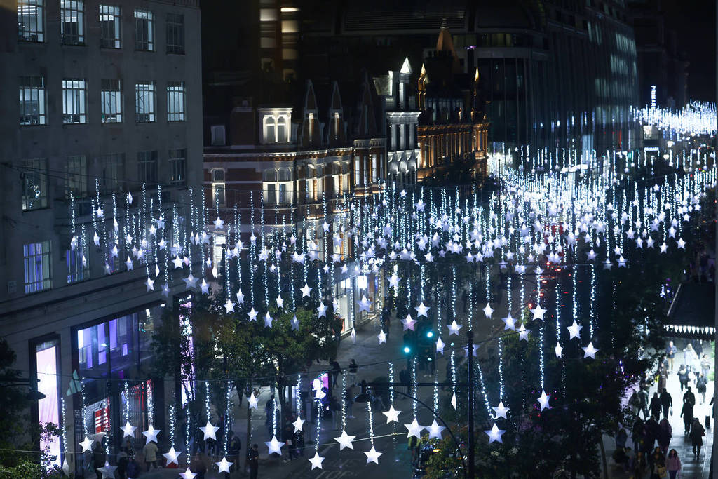 le luci natalizie scintillanti, composte da centinaia di stelle appese sopra Oxford Street, che brillano di notte