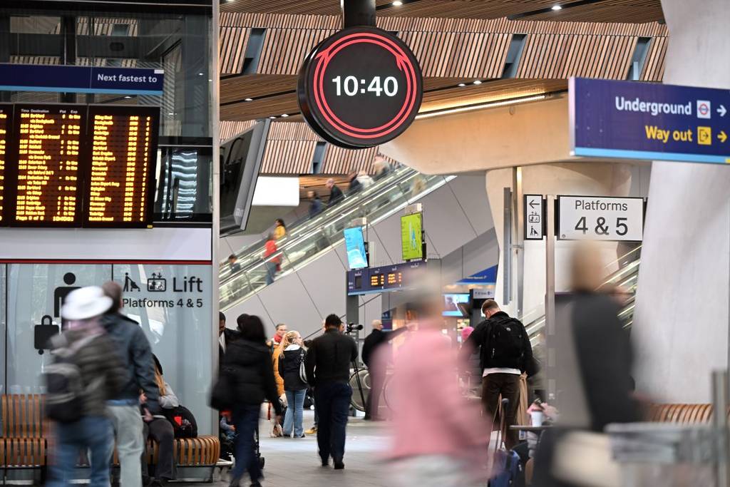 Die neue Network Rail-Uhr am Bahnhof London Bridge, während Pendler vorbeilaufen