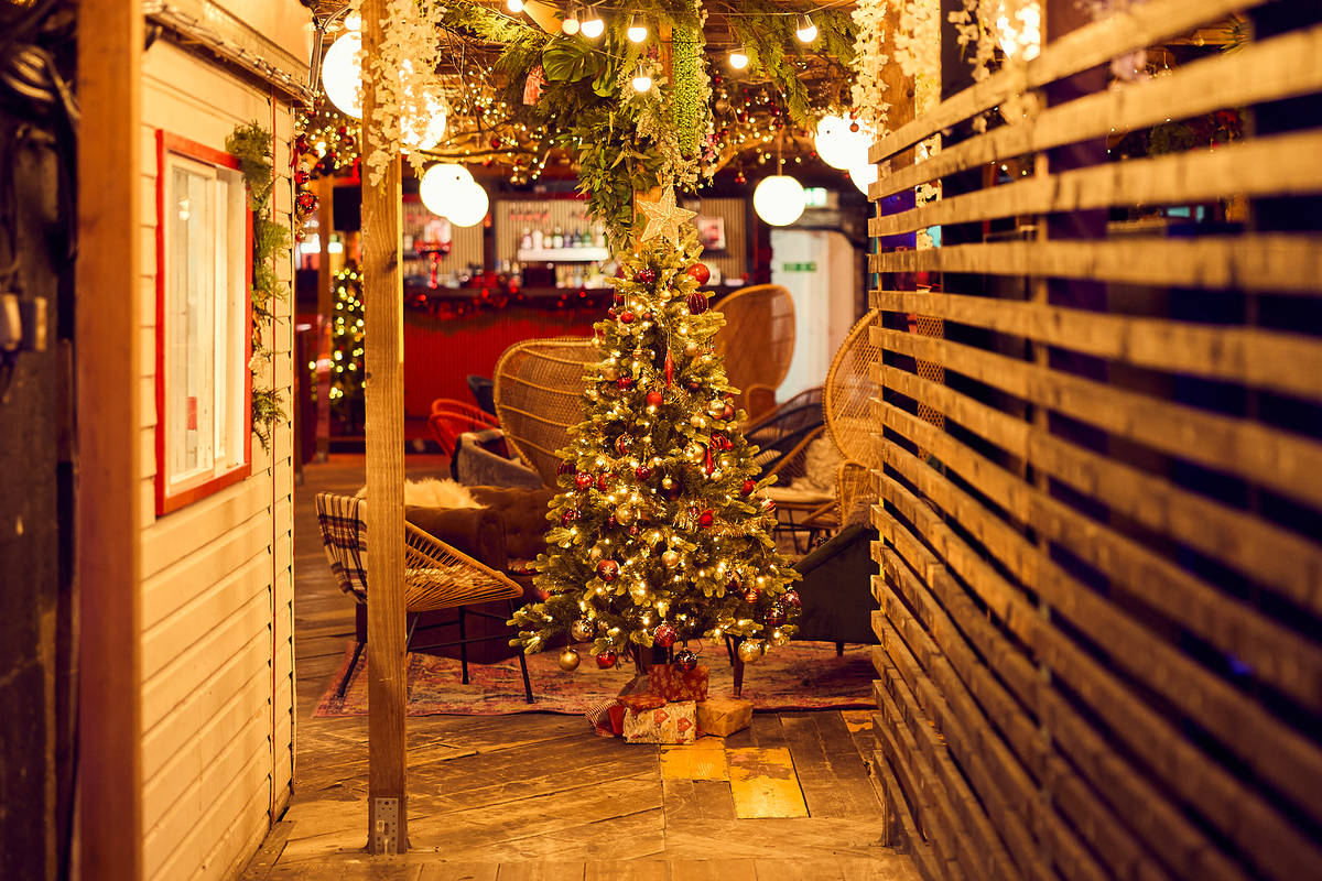 a christmas tree seen amongst cosy seating in a bar