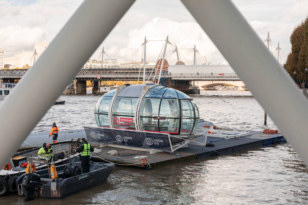 una de las cápsulas del london eye es desmontada y colocada en una barcaza